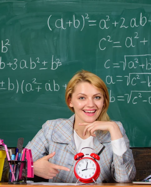 Confianza y puntualidad. Estudio y educación. Escuela moderna. Día del conocimiento. De vuelta a la escuela. Día del maestro. En la escuela. Enseñanza en casa. Mujer feliz. mujer en el aula. profesor con despertador. Tim. — Foto de Stock