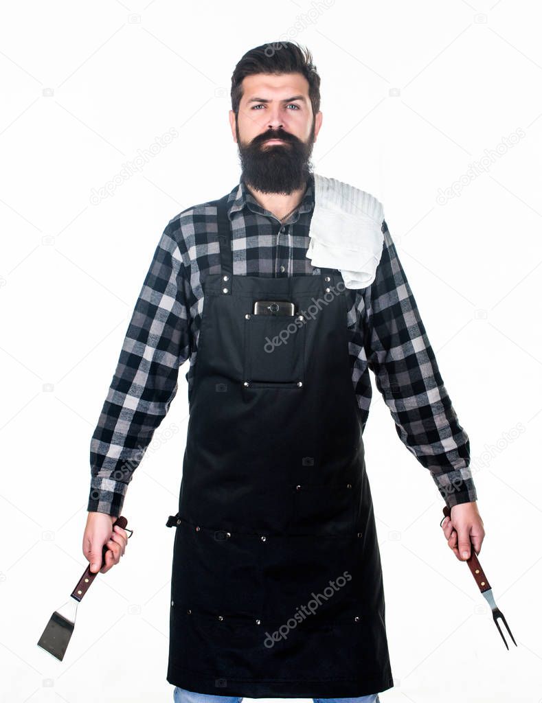 Roasting and grilling food. Man hold cooking utensils barbecue. Tools for roasting meat outdoors. Picnic and barbecue. Cooking meat in park. Barbecue master. Bearded hipster wear apron for barbecue