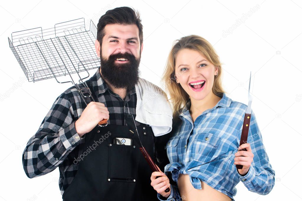 Family weekend. Couple in love hold cooking utensils for barbecue. Tools for roasting meat outdoors. Picnic and barbecue. Man bearded hipster and girl ready for barbecue party. Culinary concept
