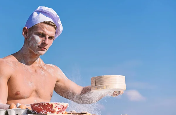 Homme boulanger musculaire ou cuire tamise la farine à travers le tamis. Boulanger avec de la farine et tamiser, pétrir la pâte. Les mains du chef cuisinier recouvert de pâte collante et de farine. Concept Pizzaiolo — Photo