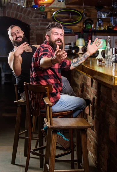 Order drinks at bar counter. Hipster brutal bearded man spend leisure with friend at bar counter. Men relaxing at bar. Friday relaxation in bar. Friendship and leisure. Friends relaxing in pub