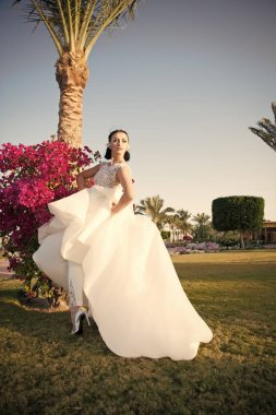 Oynak gelin. Gelin lüks beyaz gelinlik güneşli gün tropic doğa arka plan. Tropik Düğün. Kadın çok tropik düğün töreninde şaşırtıcı elbise giymek. Egzotik gelin kıyafeti