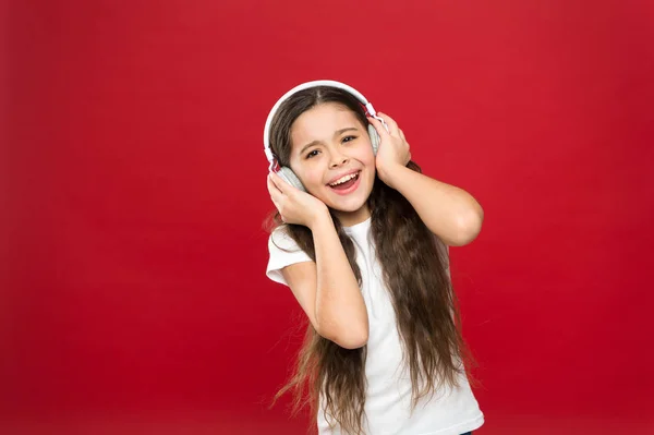 Mitsingen nach einer Melodie. kleines Mädchen beim Musikhören. kleines Kind, das Technologie für Freizeit oder Bildung nutzt. kleines Mädchen mit Stereo-Kopfhörern. Niedlicher Musikfan mit drahtlosem Headset — Stockfoto