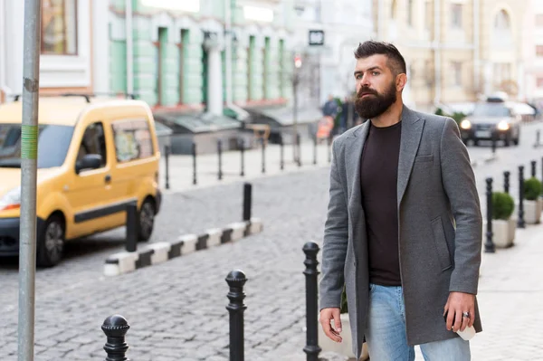 Van egy taxira. Üzletember fogása taxi, miközben állandó szabadban városi hátterű. Az ember szakállas csípő stílusú alkalmi taxi várja. A fickó utcában city Center. Keresi a szállítás. Buszmegálló — Stock Fotó