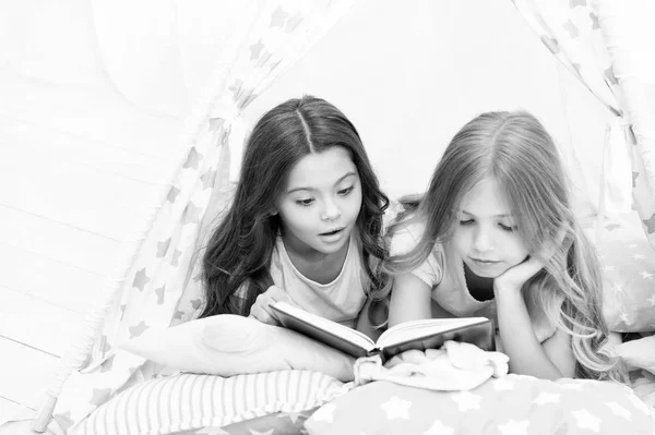 Дівчата найкращі друзі читали казку перед сном. Найкращі книжки для дітей. Діти читають книжку в ліжку. Читання перед сном може допомогти краще спати вночі. Історії, які має прочитати кожна дитина. Сімейна традиція — стокове фото