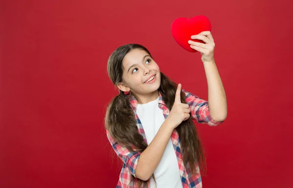 Health and healthcare. Having heart problem and heartache. Small girl pointing finger at red heart. Little child expressing love on valentines day. Cute girl in love. Happy valentines day, copy space — Stock Photo, Image