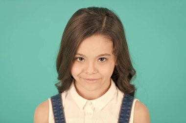 Uzun, sağlıklı, esmer saçlı çocuk modeli gülümsemesi.