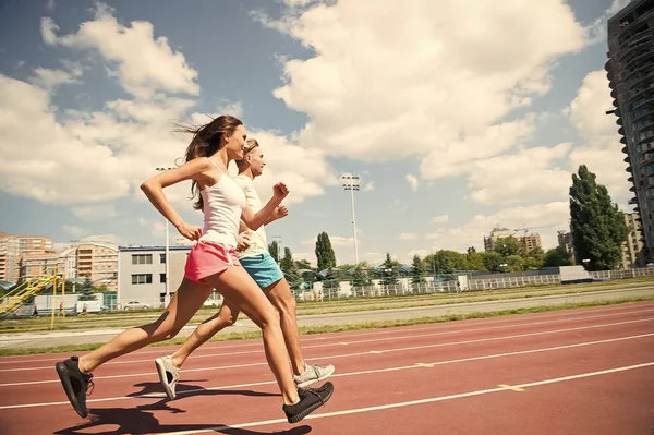 Ein paar Läufer auf sonnigem Terrain. Frau und Mann laufen im Stadion. Aktivität und Energie. Training und Training an der frischen Luft. Sport Gesundheit und Wellness — Stockfoto