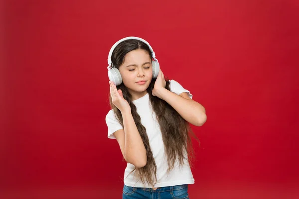 Απολαμβάνοντας την αγαπημένη μουσική. Μικρό κορίτσι φορώντας στερεοφωνικά ακουστικά. Κοριτσάκι να ακούτε μουσική. Ανεμιστήρας χαριτωμένο μουσική με ασύρματο ακουστικό. Μικρό παιδί χρησιμοποιώντας τεχνολογία για ψυχαγωγία ή την εκπαίδευση — Φωτογραφία Αρχείου