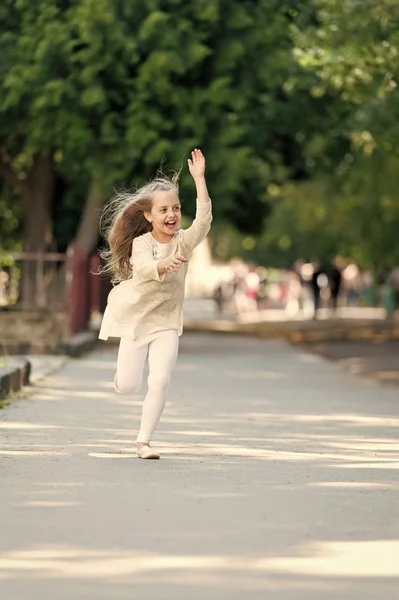 W lato park szczęśliwy dziewczyna. Małe dziecko uśmiech z latające włosy w ruch. Letnich aktywności i szczęścia. Dziecko moda bawić odkryty. Wolność i energii. Działanie dzieciństwo i aktywnych gier — Zdjęcie stockowe