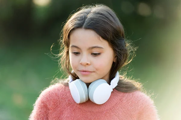 Симпатичный меломан. Маленькая девочка в наушниках. Счастливому ребенку нравится слушать музыку в дороге. Очаровательная маленькая девочка на улице. Все, что она хочет услышать, это музыку. — стоковое фото