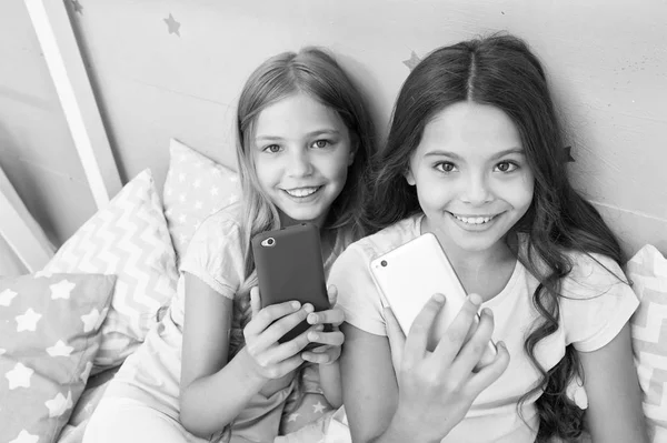 Explore social network. Kids taking selfie. Smartphone application concept. Online entertainment. Girlish leisure pajama party. Girls smartphone little bloggers. Smartphone for entertainment