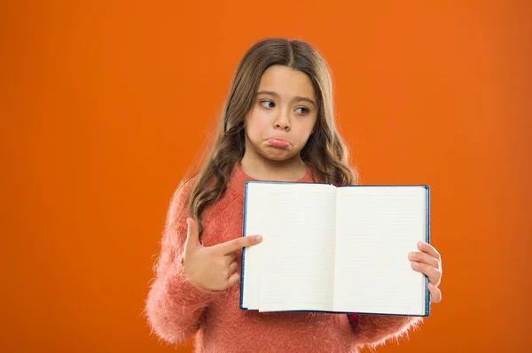 Triste noticia. Chica mantenga libro fondo naranja. Niño mostrar páginas abiertas de libro o bloc de notas. Concepto de librería. Libros gratuitos disponibles para leer. Literatura infantil. Desarrollo y educación. Mala marca — Foto de Stock