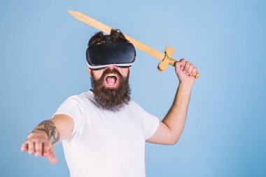 Hipster yüz bağırarak üzerinde sanal gerçeklik oyun oyun keyfini çıkarın. VR oyun kavramı. Vr gözlük, açık mavi renkli sakallı adam. Adam ile kafa monte göstermek ve kılıç oyun Vr oyun mücadele