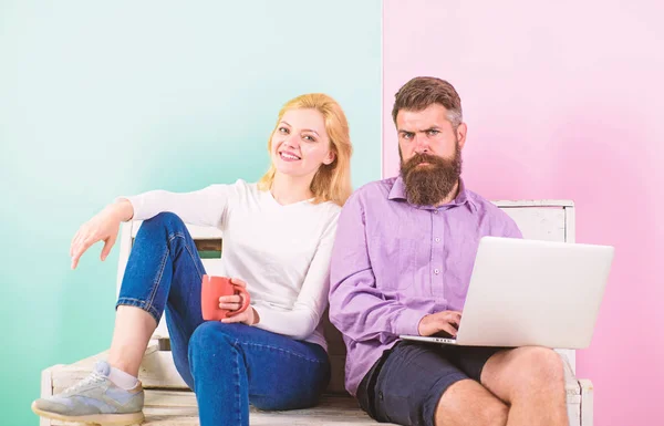 Man works as internet technologies expert on freelance. Freelance benefits. Girl enjoy drink while husband freelancer works with laptop. Woman smiling face drink tea or coffee near man working