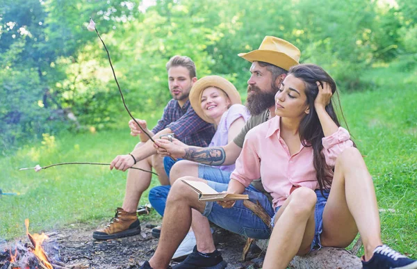 Caminhadas de férias para jovens. Os caminhantes passam o lazer no fundo da natureza da floresta. Caminhantes sentam-se perto da fogueira relaxando enquanto esperam assar comida. Os caminhantes organizaram um piquenique rápido para comer e relaxar. Caminhe ideias de piquenique — Fotografia de Stock