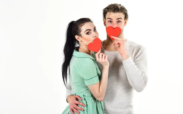 Hombre y mujer pareja en el amor tienen tarjeta de corazón rojo sobre fondo blanco. Pareja romántica en el amor abrazo. Hombre guapo sin afeitar y chica guapa enamorada. Concepto de sentimientos románticos. Día de San Valentín y amor — Foto de Stock