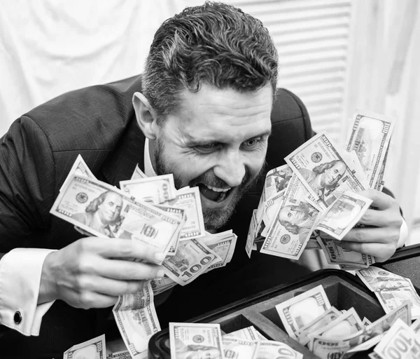 Hombre guapo feliz y sorprendido con el dinero cientos de dólares en caso. Retrato de un joven empresario feliz lanzando billetes de dinero. El dinero calcula. Beneficio, primer plano . — Foto de Stock