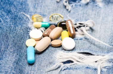 Doz ve bağımlılığı. Uyuşturucu bağımlılığı. İlaç ve tedavi kavramı. Uyuşturucu denim arka plan üzerinde. Renkli hapları kümesi. İlaçlar karıştırma. Hızlı tedavi. İlaç reçete. Sağlık ve hastalık