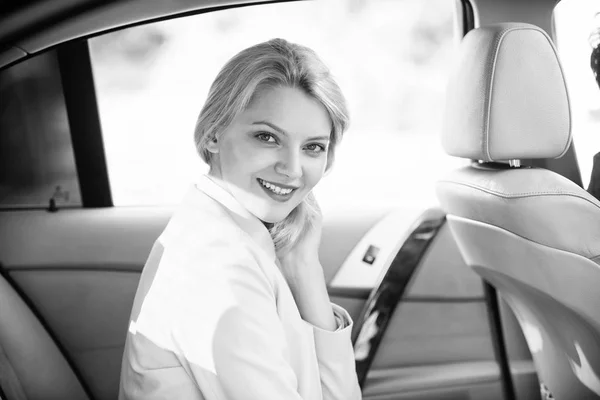 Personal assistant and driver. Business life concept. Business woman sit on backseat. Busy lady passenger leather car salon enjoy journey with chauffeur. Business lady passenger luxury car salon — Stock Photo, Image