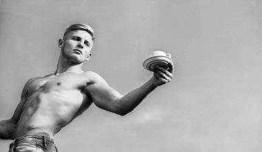 Garson çıplak göğüs kahve fincanı tutun. Maço kas göğüs çıplak gövde tutun bir fincan taze kahve mavi gökyüzü arka plan. Seksi gövde çekici garson. Adam kas atlet vücut geliştirmeci kahve sunuyor.