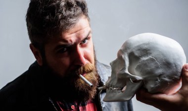 Sağlık yok. Sigara zararlı olduğunu. Tütün Sigara içmeyi alışkanlık vücudunuza zarar getir. Adam ölüm sembolü insan kafatası yakınındaki Sigara İçilmeyen. Zararlı alışkanlıklar. Sigara sağlık zarar ve ölüm