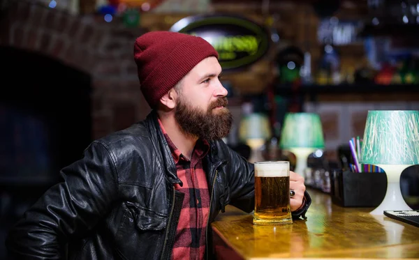 Pub gran lugar para cenar beber y divertirse. Hipster relajándose en el pub. El hombre con barba pasa el tiempo libre en el pub oscuro. Brutal hipster relajándose. El tipo barbudo se sienta en el mostrador del bar en el bar. Estilo de fin de semana — Foto de Stock