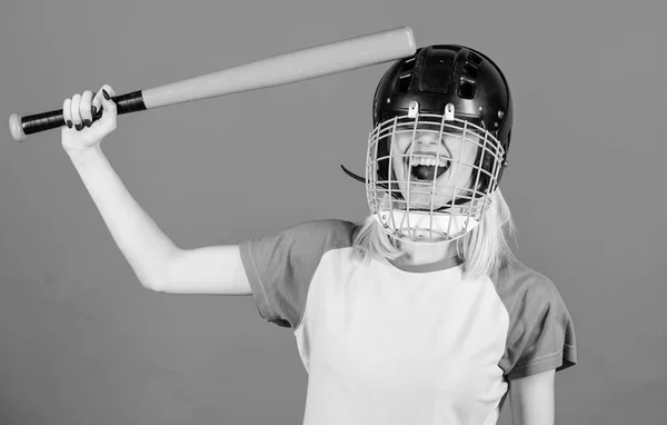 Chica bonita rubia usar casco de béisbol y mantener el bate sobre fondo azul. Golpéale la cabeza con un bate. Concepto de idea tonto. La chica sólo quiere divertirse. Juega por diversión. Mujer divirtiéndose durante el béisbol juego — Foto de Stock