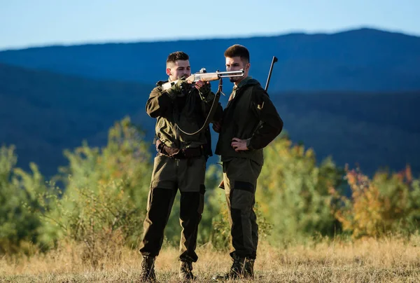 Hunting skills and weapon equipment. How turn hunting into hobby. Friendship of men hunters. Army forces. Camouflage. Military uniform fashion. Man hunters with rifle gun. Boot camp. Male with a gun