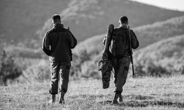 Avcı arkadaş eğlence keyfini çıkarın. Avcılar arkadaşlar gamekeepers dağlar arka plan yürümek. Avcılık ortağı ile daha fazla ölçü emniyet kez eğlenceli ve ödüllendirici sağlar. Avcı tüfekler doğa ortam — Stok fotoğraf