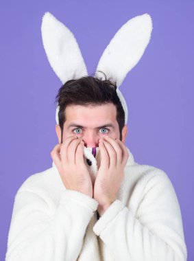 Sevimli tavşan. Adam yakışıklı yüzü giyim beyaz tavşan kulaklar. Paskalya tavşanı. Beyaz bunny Paskalya tatili sembolü. Yumuşak ve yumuşak. Adam uzun bunny veya tavşan kulaklara menekşe arka plan ile. Tendernes keyfini çıkarın