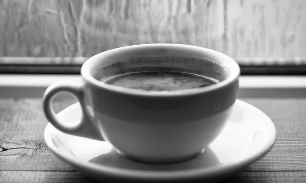 Vers gebrouwen koffie in witte kopje of mok op de vensterbank. Koffie tijd op regenachtige dag. Natte glazen raam en kop warme koffie. Herfst bewolkt weer beter met cafeïne drinken. U geniet van koffie op regenachtige dag — Stockfoto