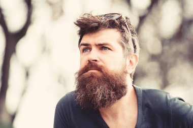 Düşünceli erkek mavi gözlü gökyüzü, huzur ve mindfulness kavramı içine arıyorum. Hipster kafasında parkta dolaşmaya güneş gözlüklü genç sakallı