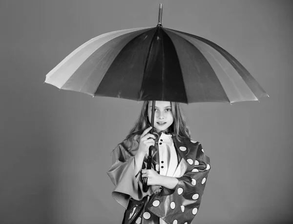 防水配件制造。穿着合适的衣服享受多雨的天气。防水配件使雨天愉快和愉快。孩子女孩高兴举行五颜六色的伞穿防水斗篷 — 图库照片