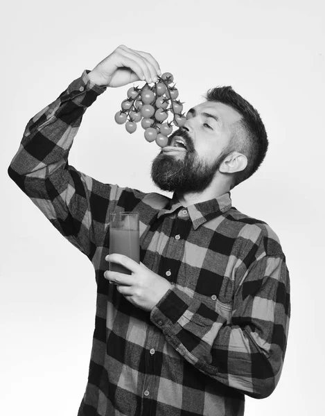 Mann mit Bart hält Glas Saft und isst Gemüse — Stockfoto