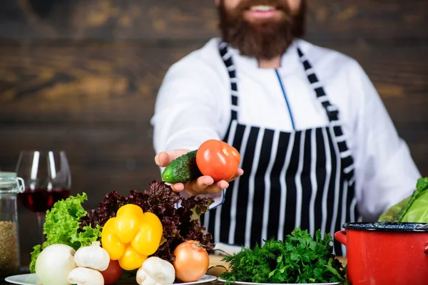 Mannen skäggig hipster slitage förkläde matlagning hälsosam mat. Vegetarisk livsstil. Kocken tillaga utsökt måltid trä bakgrund. Förälskad i hälsosamma livsmedel. Hunger och aptit. Hälsosam Vegetarisk recept — Stockfoto