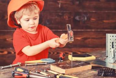 Kavram handcrafting. Yürümeye başlayan çocuk meşgul yüzündeki çekiç aracı evde atölye ile oynuyor. Çocuk Çocuk tamirci oynamak. Çocuk kask Oluşturucu veya repairer, onarımı veya handcrafting olarak oynayan sevimli içinde