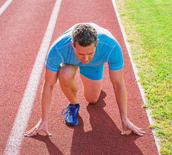 Atlet pelari berkonsentrasi pada posisi start rendah. Runner mengambil bagian kompetisi posisi start rendah. Fokus pada tujuan olahraga. Siap untuk mencapai kemenangan. Atlet pria fokus pada perlombaan lari siap untuk pergi. — Stok Foto