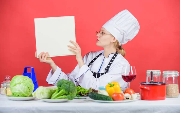 Traditional cuisine. Culinary expert. Woman chef cooking healthy food. Girl read book top best culinary recipes. Culinary school concept. Female in hat and apron knows everything about culinary arts