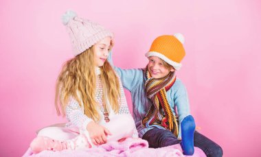 Çocuklar kış şapka örme. Çocuklar için Kış Aksesuarları. Kız ve erkek örme kış şapka giyerler. Kış sezon moda aksesuarları ve giyim. Çocukların neşeli ruh hali Noel tatil pembe arka plan