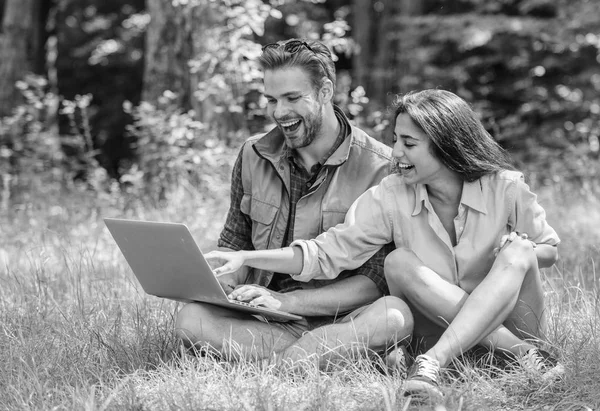 Modern technologies give opportunity to be online and work in any environment conditions. Freelance opportunity. Man and girl looking at laptop screen. Couple youth spend leisure outdoors with laptop