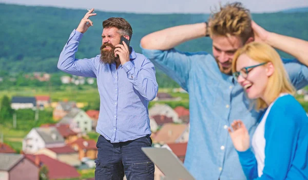 Pareja divirtiéndose mientras Internet navegar al aire libre. Un par de colegas coqueteando mientras jefe ocupado con la conversación móvil. Beneficios de Internet móvil. Colegas utilizan videoconferencia en su lugar llamada móvil — Foto de Stock