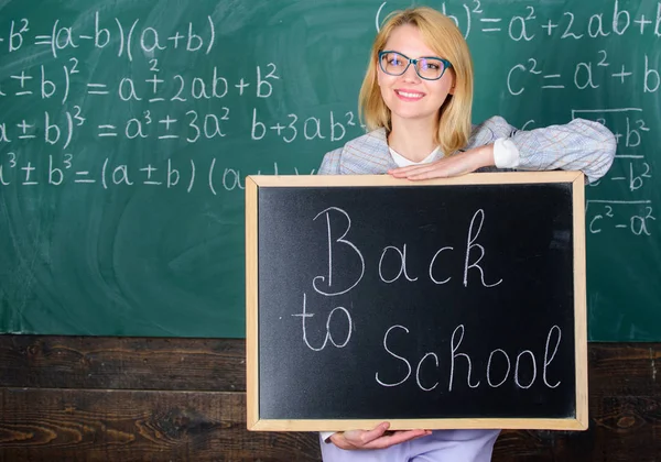 Meilleures façons d'accueillir les élèves à l'école. La maîtresse garde l'inscription au tableau noir à l'école. C'est encore l'heure de l'école. Professeur heureux d'accueillir les élèves. Commencer l'école oui — Photo