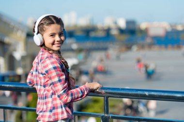 Gittiğin her yerde müzik var. Çocuk açık havada müzik dinliyor modern kulaklıklar. Küçük kız şarkı kulaklığı dinliyor. Müzik hesabı çalma listesi. Müziğini özelleştir. Şehirli çocuk eğlencesi. Küçük çocuk dinleniyor.