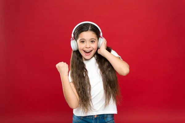 Play list concept. Music taste. Music plays an important part lives teenagers. Powerful effect music teenagers their emotions, perception of world. Girl listen music headphones on red background — Stock Photo, Image