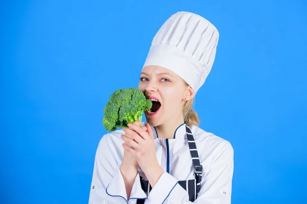 Nainen ammatillinen kokki pitää raaka parsakaali vihannes. Ilmaisia terveellisiä kasvis- ja vegaanireseptejä. Terveellistä raakaa ruokaa. Laihdutussuunnitelma. Syö terveellisesti. Tyttö käyttää hattua ja esiliina pidä vihanneksia. Terveellinen annos — kuvapankkivalokuva