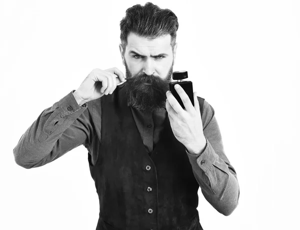 Hombre barbudo sosteniendo perfume con cara seria — Foto de Stock
