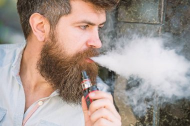 Adam duman e-sigara vurguladı. Yan görünümü vape teneffüs edilmesi adam sakallı. Stres rahatlama ve gevşeme kavramı