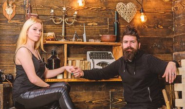 Kız ve erkek rahat yüzleri sıcak atmosferinin keyfini çıkarın. Çift gamekeepers evde, ahşap iç arka plan romantik akşamın. Aşık çift birlikte ellerini tutar. Romantik akşam kavramı