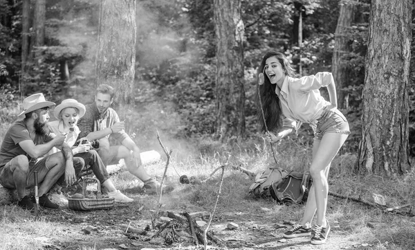 Randonnée de week-end. Pique-nique avec des amis dans la forêt près du feu de joie. Les randonneurs partagent l'impression de marcher et de manger. Compagnie ayant un fond de nature de pique-nique randonnée. Touristes avec appareil photo relaxant vérifier les photos — Photo